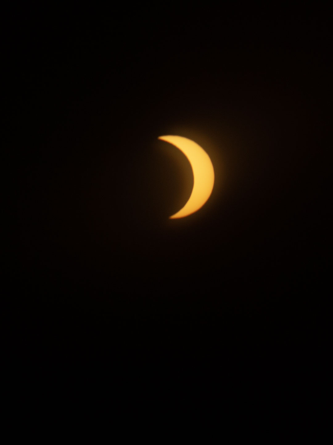 Die Sonne als orange Sichel, zum großen Teil verdeckt